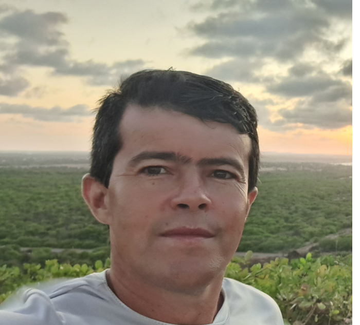 Montador de móveis bairro Cruzeiro/Betim com camisa branca e uma paisagem no fundo da imagem 